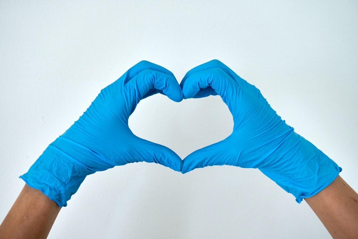 Cleaning professional making heart hands with blue rubber gloves in Chula Vista CA